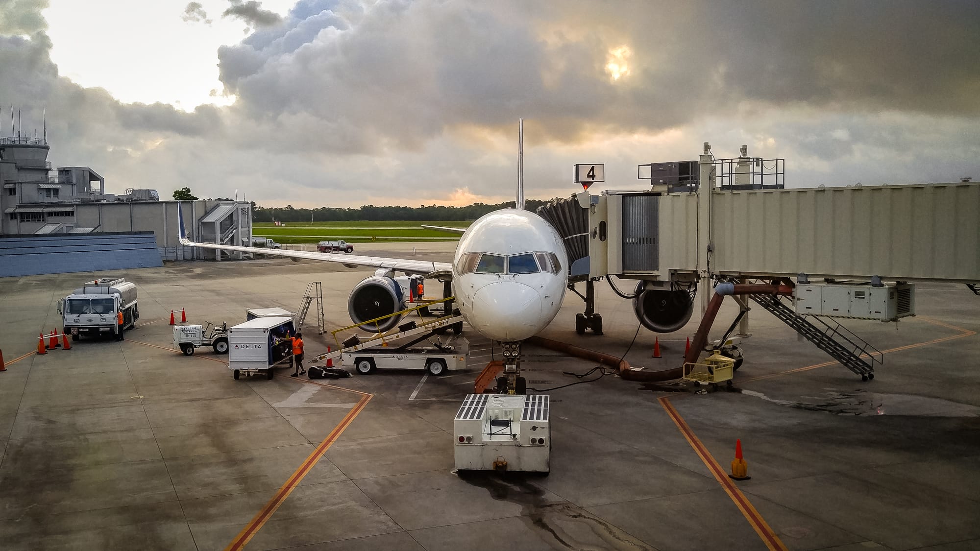 A head-on view of a Delta Airlines plane with the jet bridge attached at Pensacola International Airport.