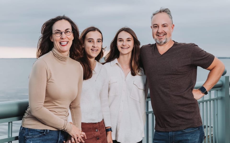 The Nickinson family standing along a railing on Pensacola Bay. From left, Shannon, Isabella, Mia, and Phil.